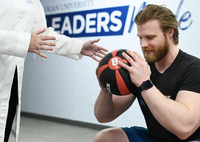 Athlete working with physical trainer.